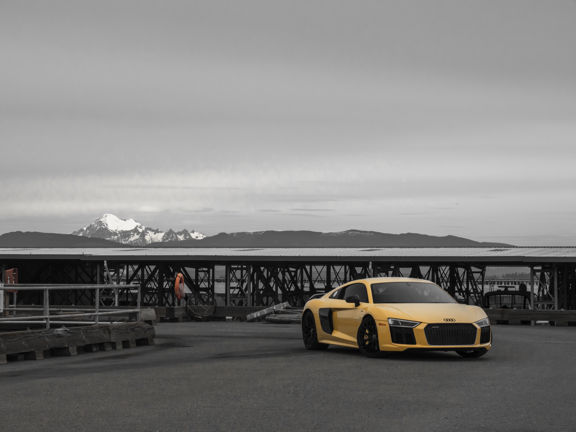 Yellow Audi parked before a mountain landscape